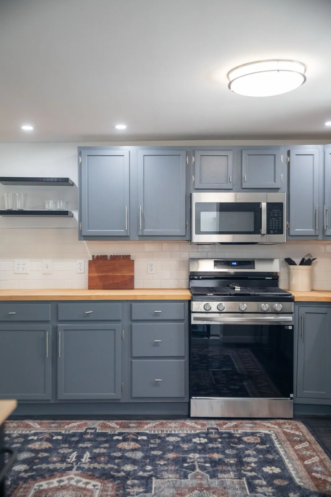 Kitchen range and microwave with blue-gray cabinetry at 61 H Street, Lake Lotawana