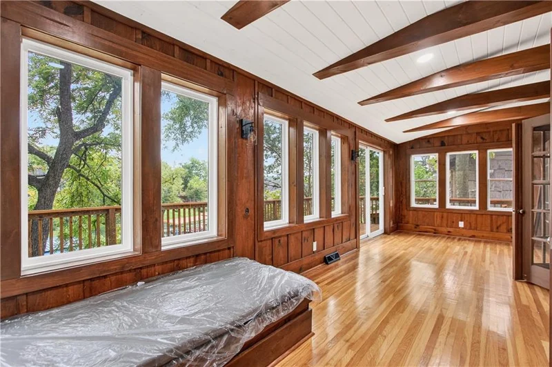 Window-lined living space looking out to the trees and the lake