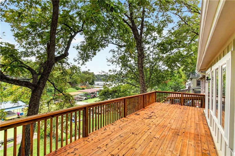 Deck under mature trees with views across the cove