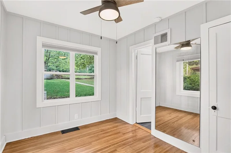 Bedroom with a ceiling fan and mirrored closet doors