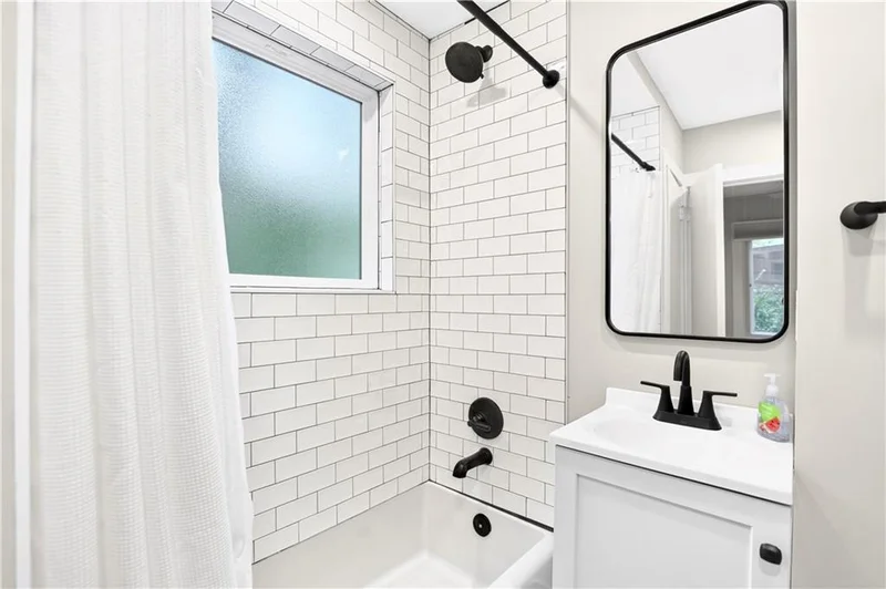 Remodeled bathroom with white subway tile and black fixtures