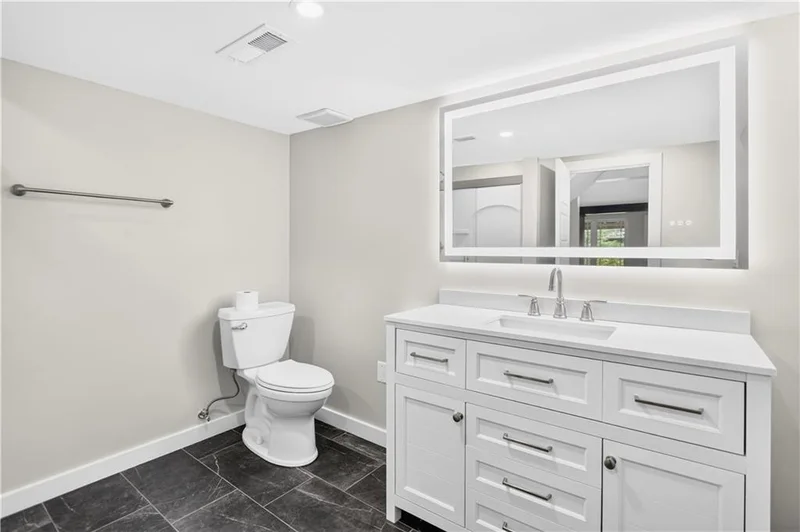 Lower-level bathroom with a white vanity